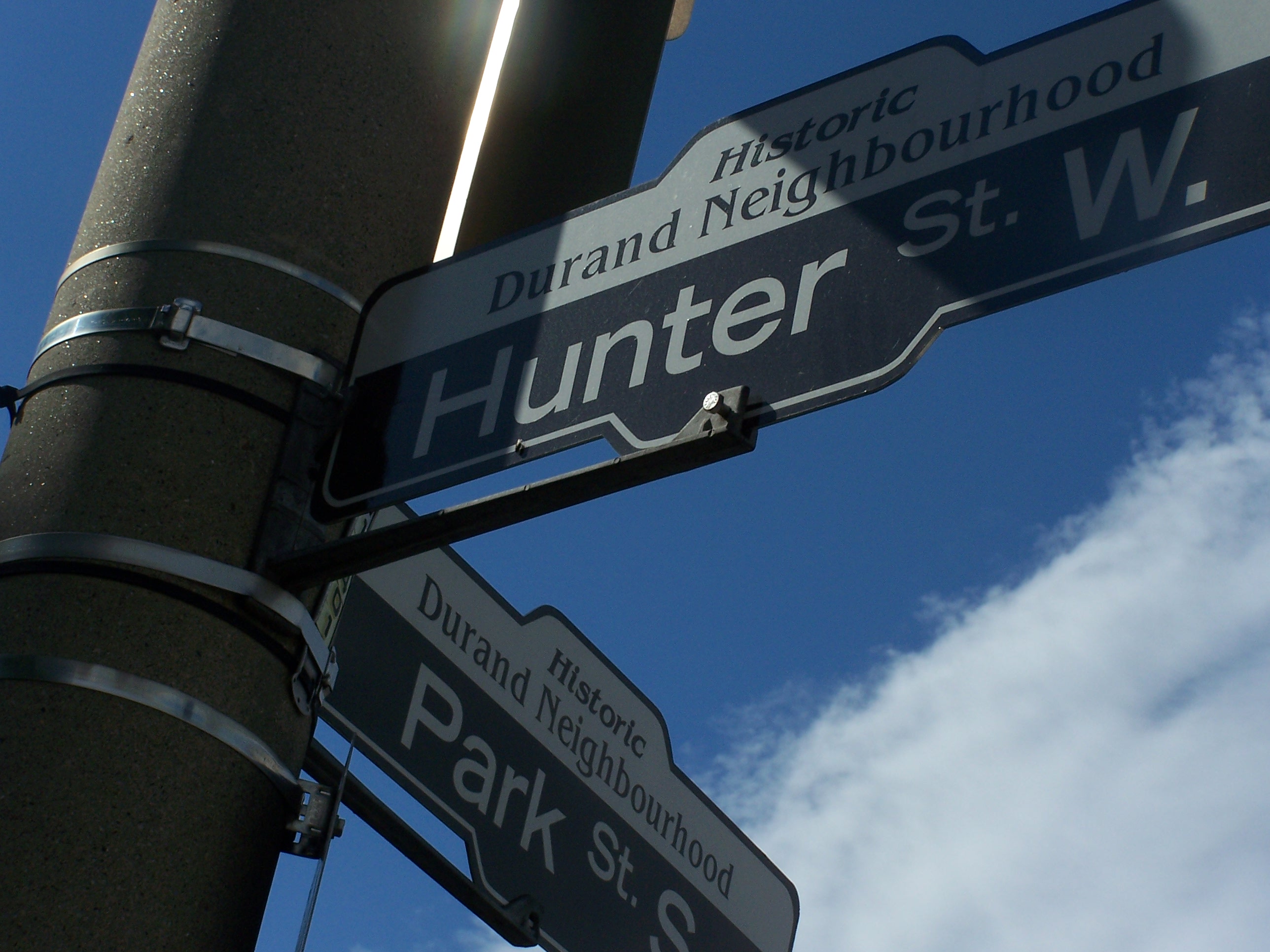 two street signs cast in a dramatic shadow.