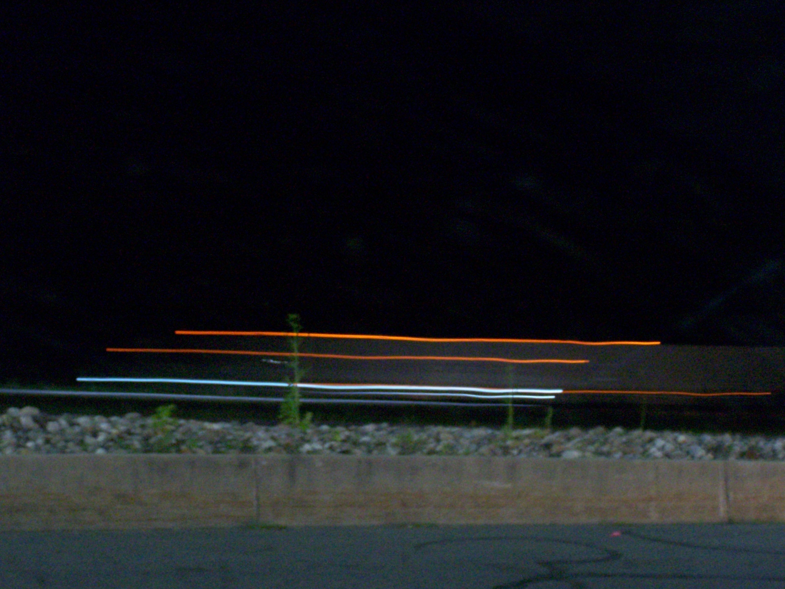 pitch black image with streaks of horizontal amber and light blue going across.