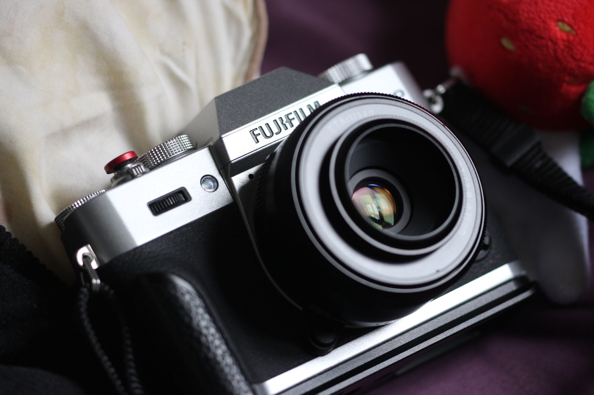 close up high constrast photograph of a rectangular camera with a hump on the top. the main body is black and the top section is silver.