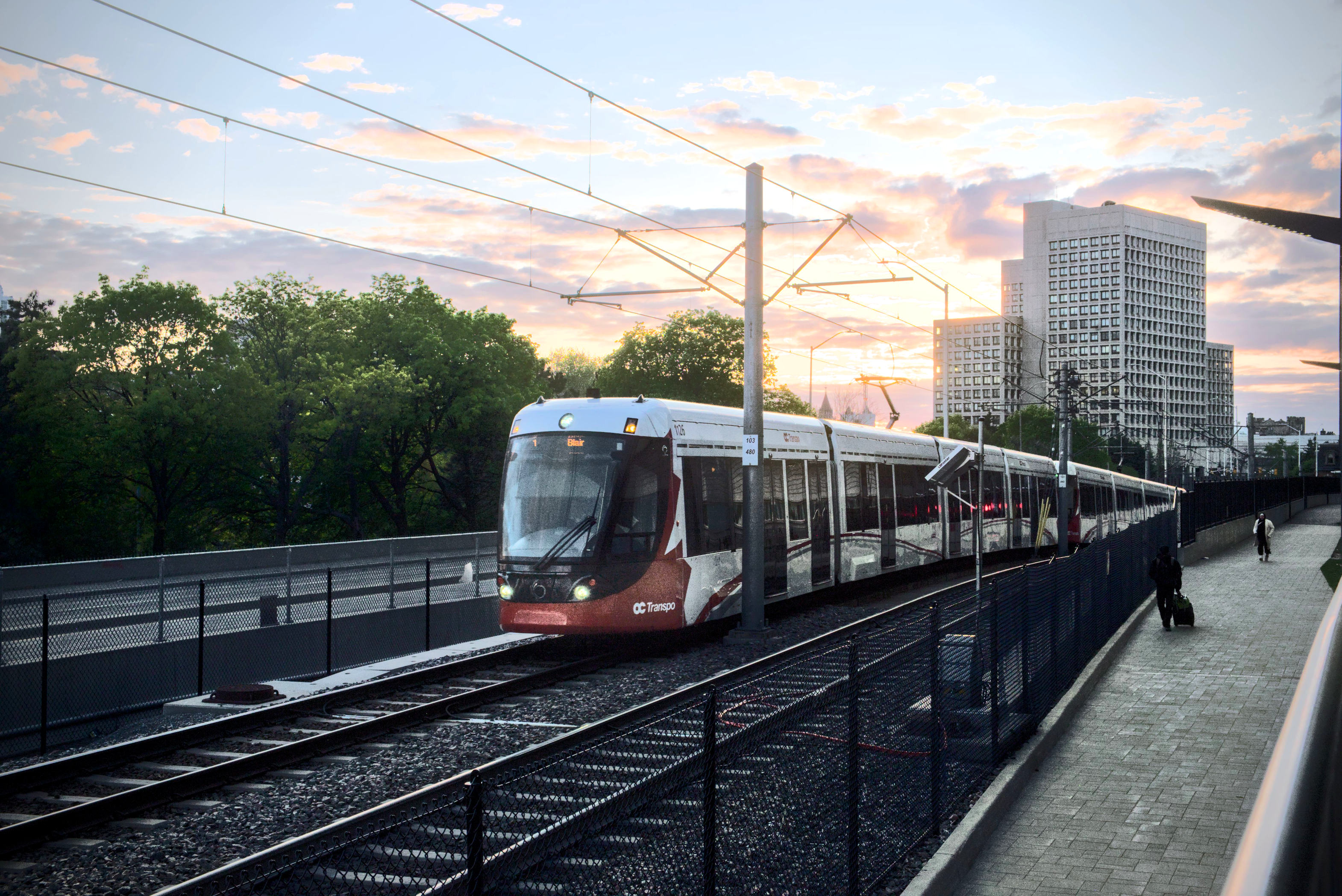8 car tram train in front of a skyline during sunset background.