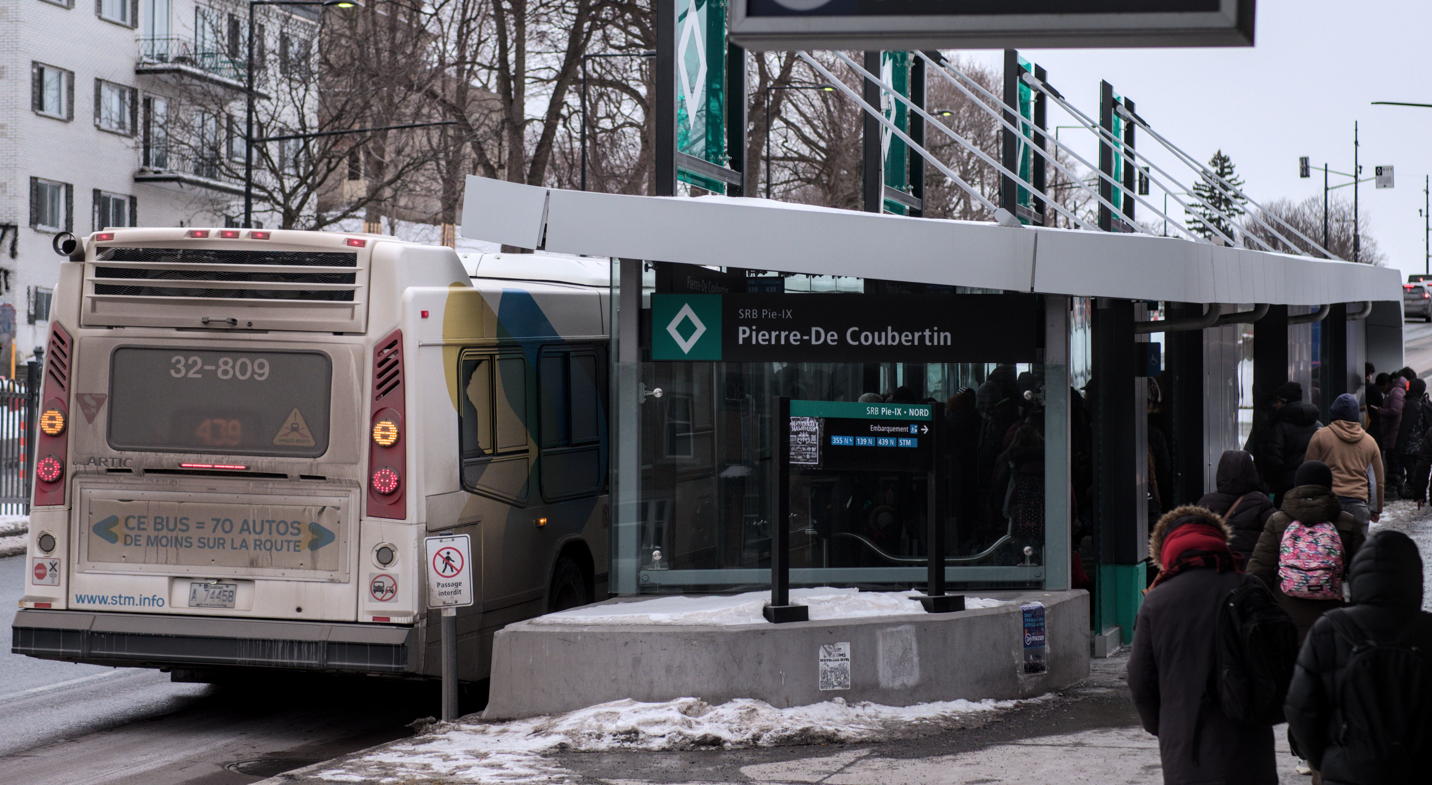 articulated bus with an ad about less cars on the road at a SRB station,