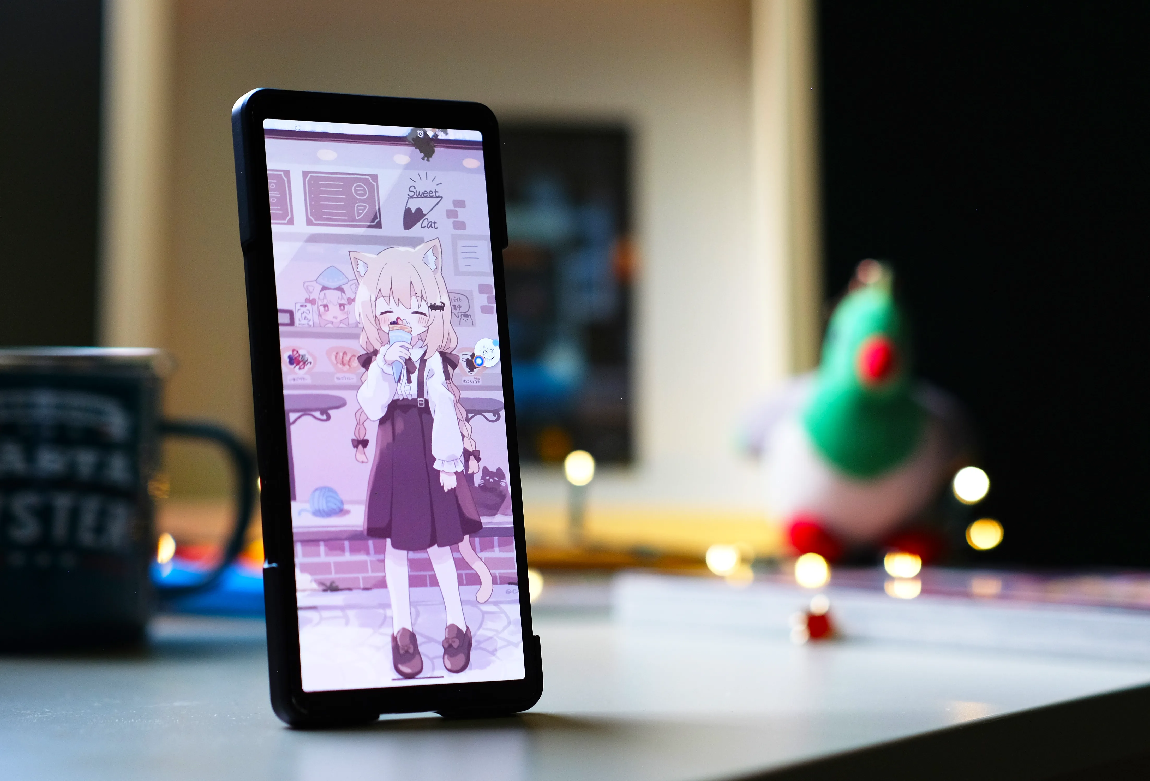 xperia 5 V phone in a still life image. the screen has an image of a catgirl eating icecream and a bubble of a conversation with Em.