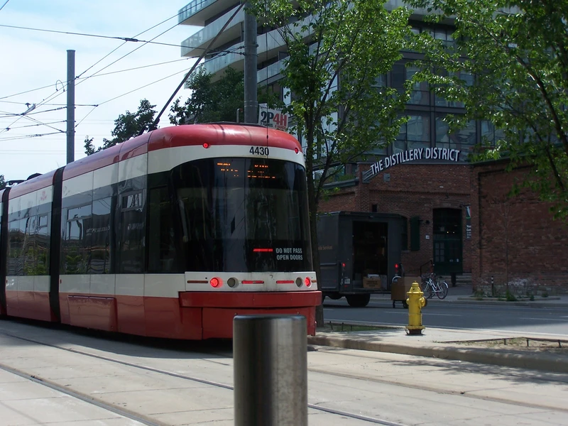 trolley streetcar from behind, close to a pretty area called distillery.