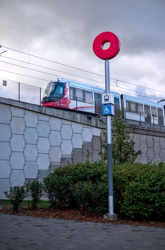 alstom citadis spirit on a viaduct in front of a metro roundel.