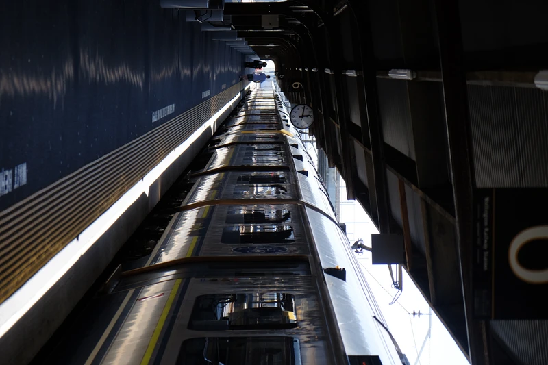 photo of long matangi train at a station with loads of dramatic reflected light