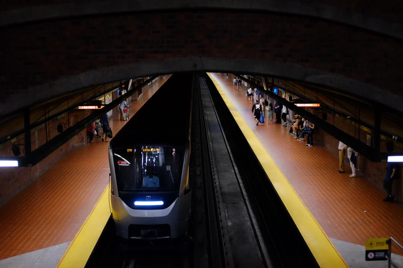 subwayu train in a tunnel at a station, as seen from above.