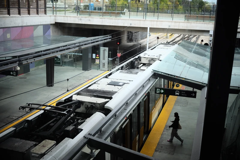 photo from above citadis spirit at a station while a single person walks to enter the door.